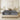 Front view of Springfit BetterSpine Elevate mattress with dark charcoal quilted top and beige pillows on cream upholstered bed