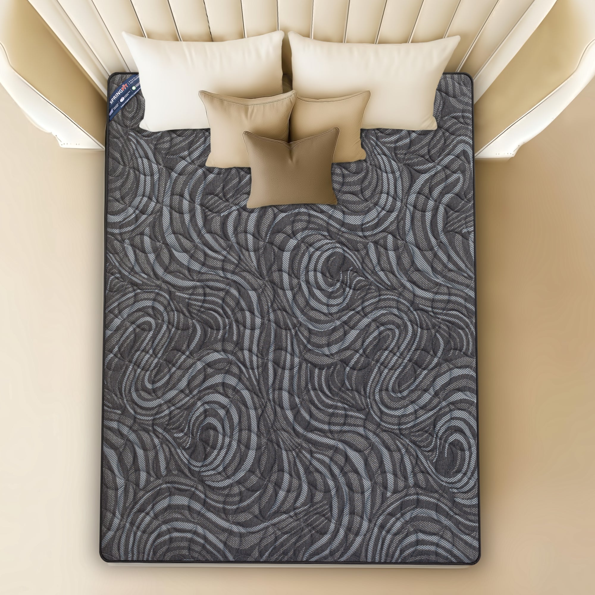 Top-down view of Springfit BetterSpine Elevate mattress showing distinctive dark swirl-pattern knitted fabric surface with beige pillows