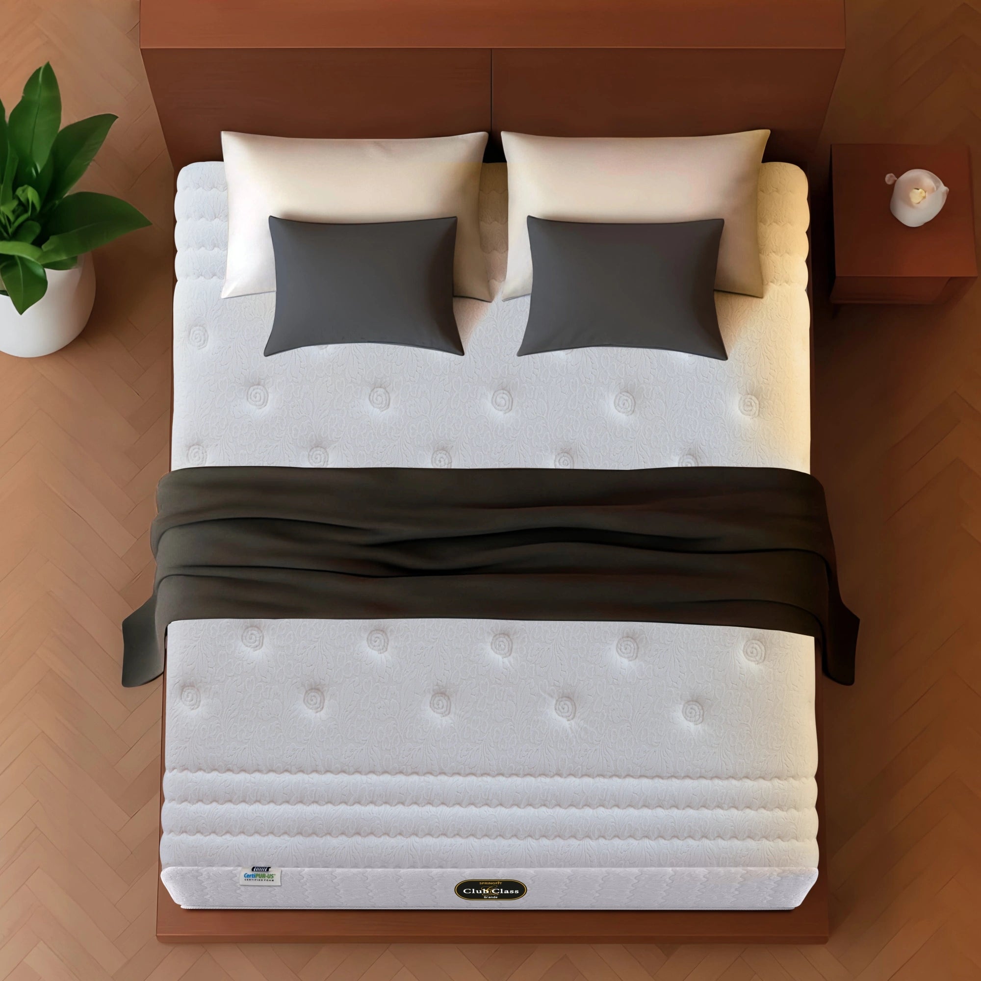 Springfit Club Class Grande mattress aerial top view showing white premium spiral-tufted jacquard fabric with dark throw on walnut bed frame with beige and grey pillows on herringbone floor