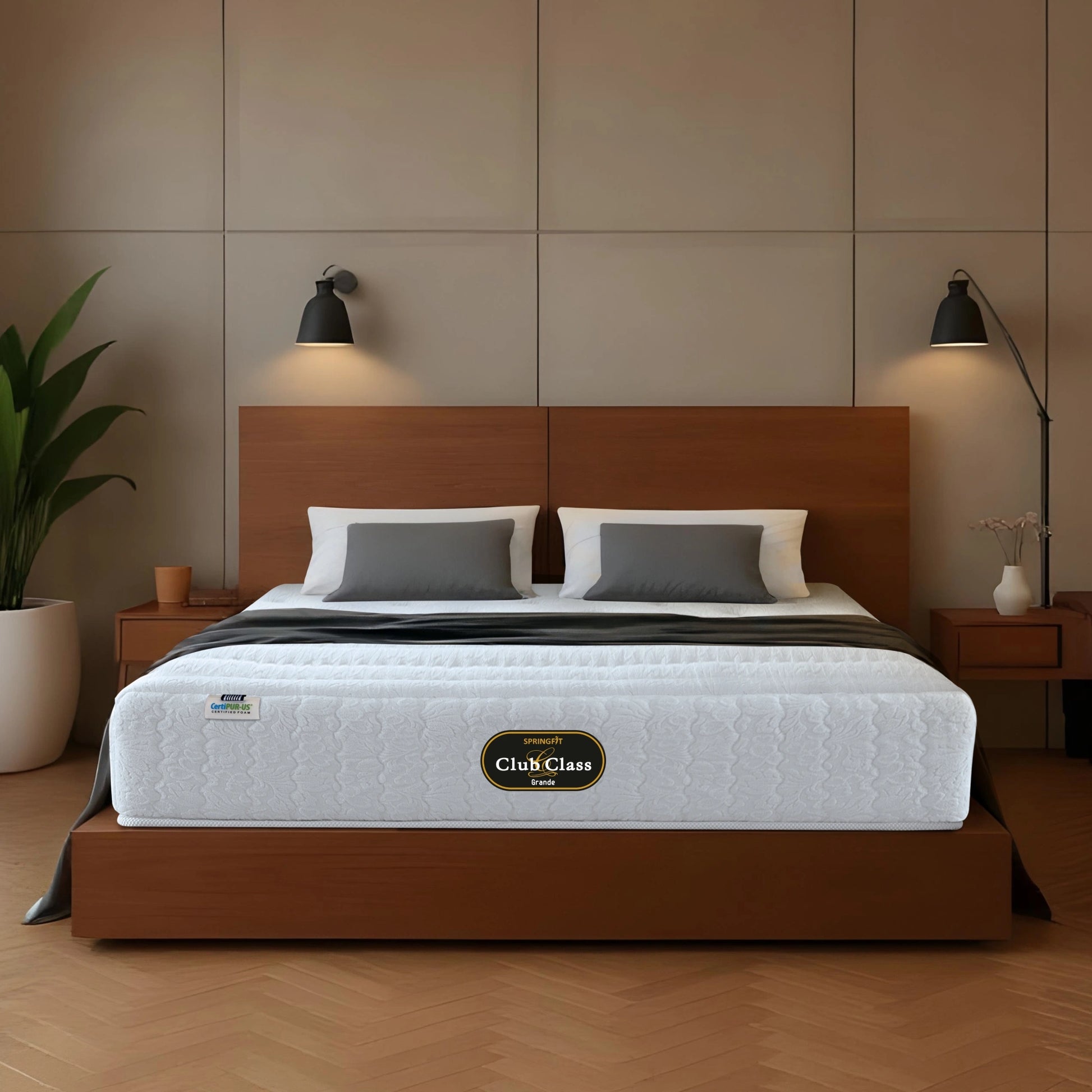 Springfit Club Class Grande mattress on walnut platform bed with white and grey pillows and dark throw in warm industrial-style bedroom with concrete panel wall, twin black wall sconces, and wooden nightstands