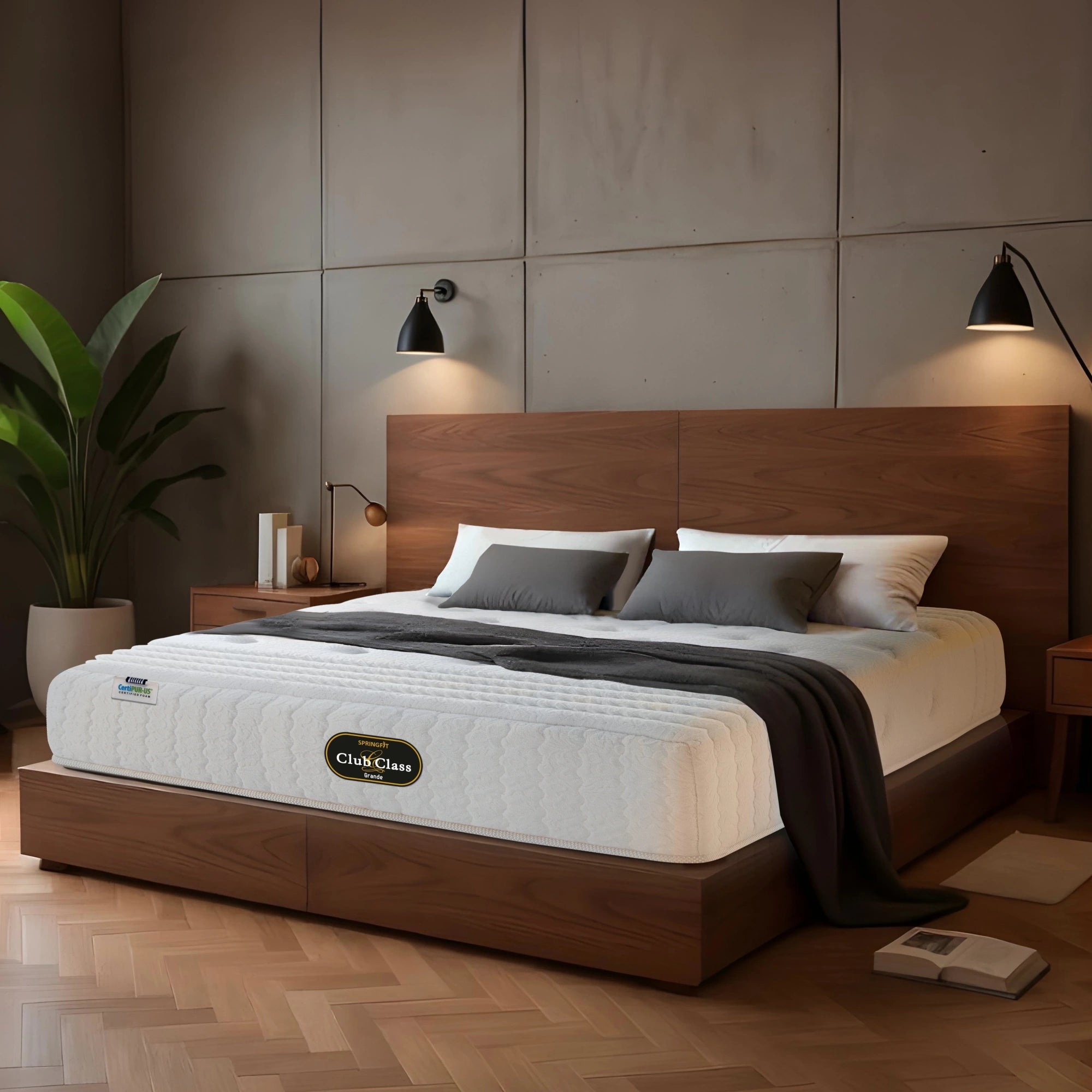 Springfit Club Class Grande mattress on walnut platform bed with grey and white pillows in warm industrial-style bedroom with concrete panel wall, black wall sconces, indoor plant, and herringbone floor