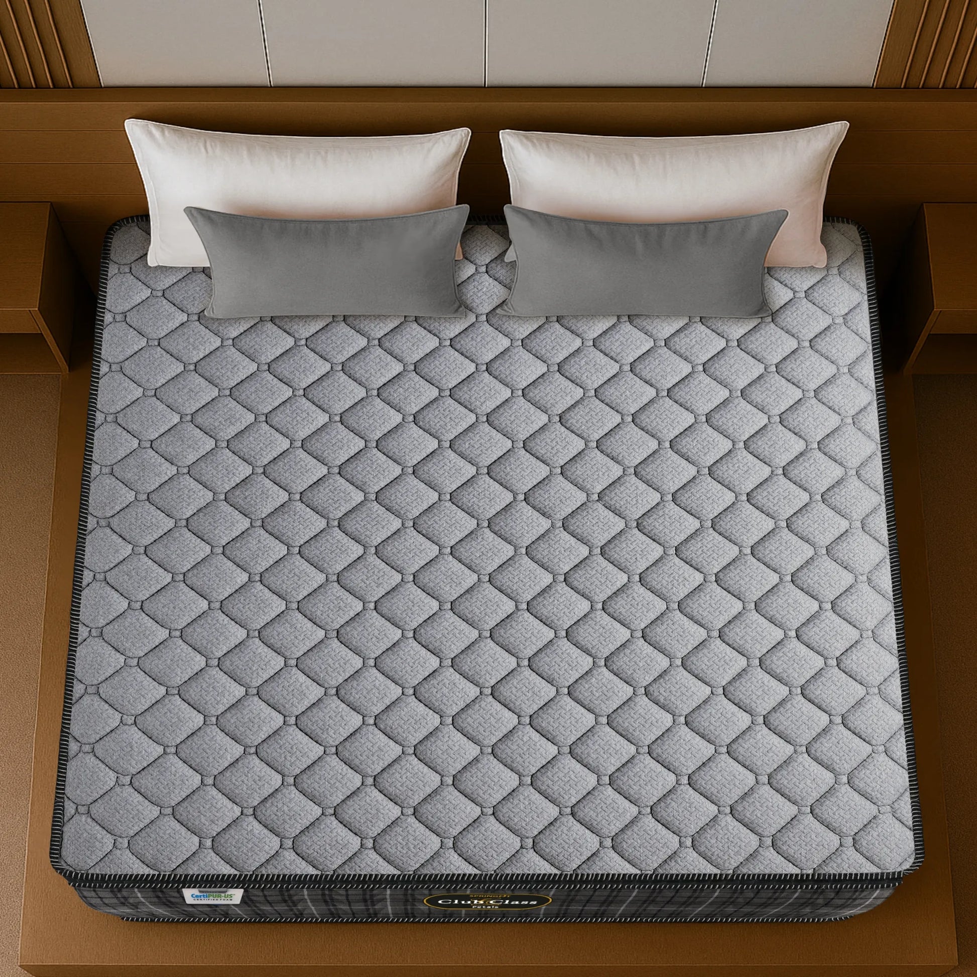 Springfit Club Class Petals mattress aerial top view showing grey diamond-quilted knitted fabric with black border on wooden bed frame with white and grey pillows