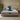 Springfit iSleep Blue mattress on a low wooden platform bed in a warm boho bedroom with textured plaster walls and indoor plants, with a brand ambassador in teal loungewear joyfully stretching her arms overhead