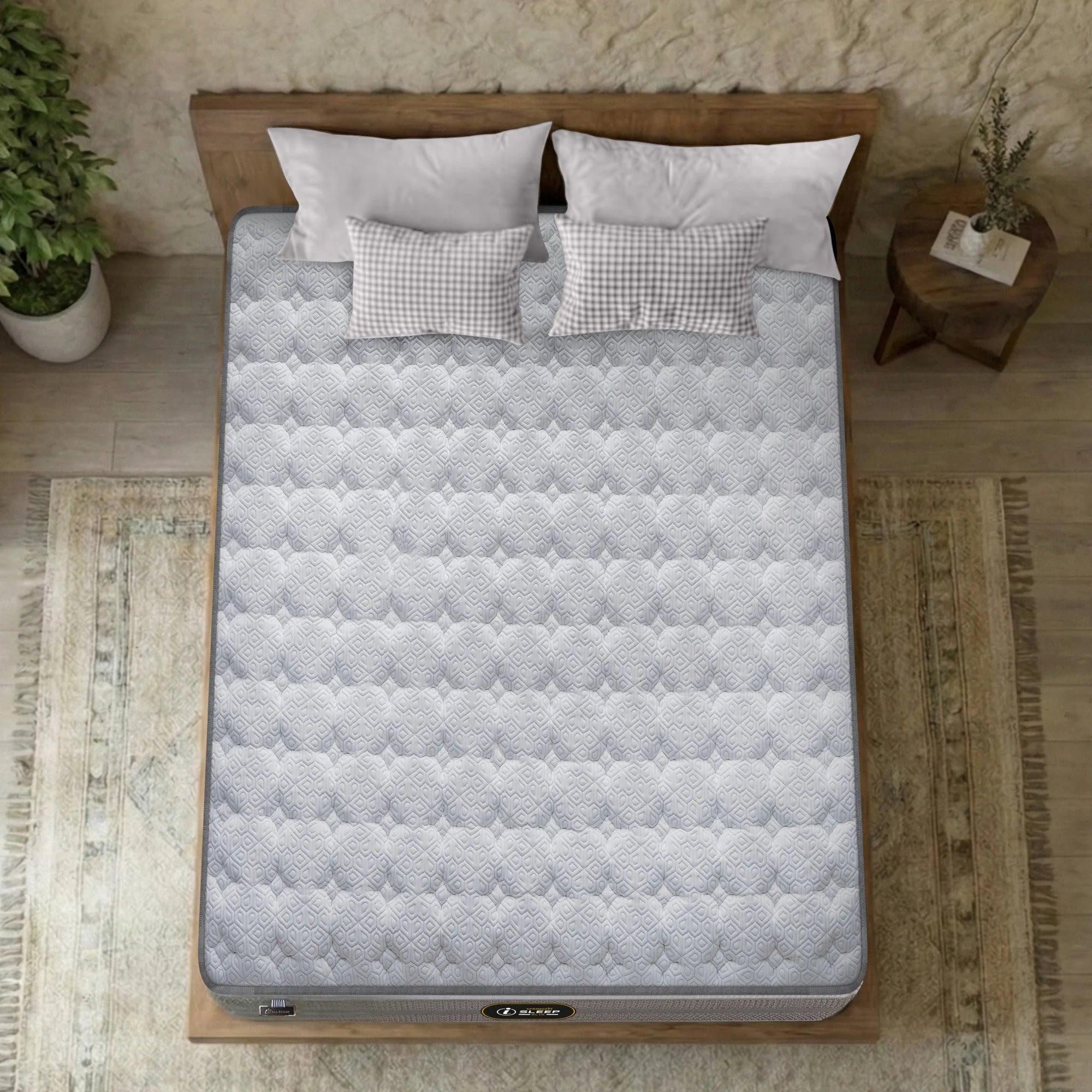 Overhead top-down view of the Springfit iSleep Blue mattress showing its full white diamond and hexagon-quilted surface on a natural wood platform bed with gingham and white pillows