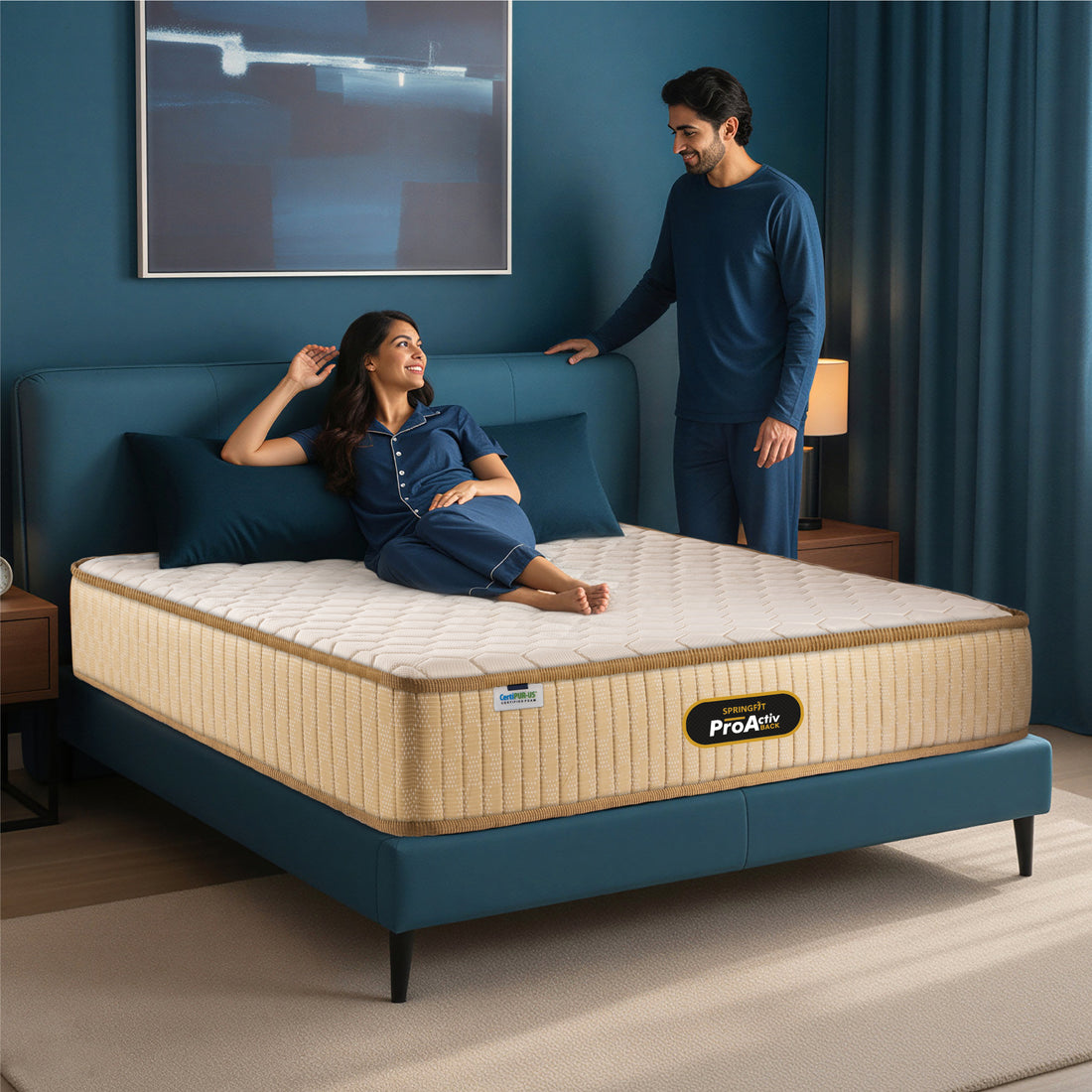 Springfit ProActiv Back mattress with couple in matching navy nightwear in teal accent bedroom with wooden nightstands and warm lamp lighting