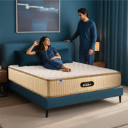 Springfit ProActiv Back mattress with couple in matching navy nightwear in teal accent bedroom with wooden nightstands and warm lamp lighting