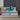 Springfit ProActiv Flow mattress lifestyle image with brand ambassador in teal outfit seated on bed with beige tufted headboard in blue-grey accent bedroom with gold lighting