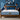 Springfit Reactive Dual mattress with smiling couple in matching navy outfits pressing the mattress surface on wooden bed frame in blue accent bedroom with abstract wall art