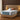 Springfit Reactive Dual Memory mattress on beige channeled platform bed with light blue and terracotta pillows in warm wood-paneled luxury bedroom with golden side lamps