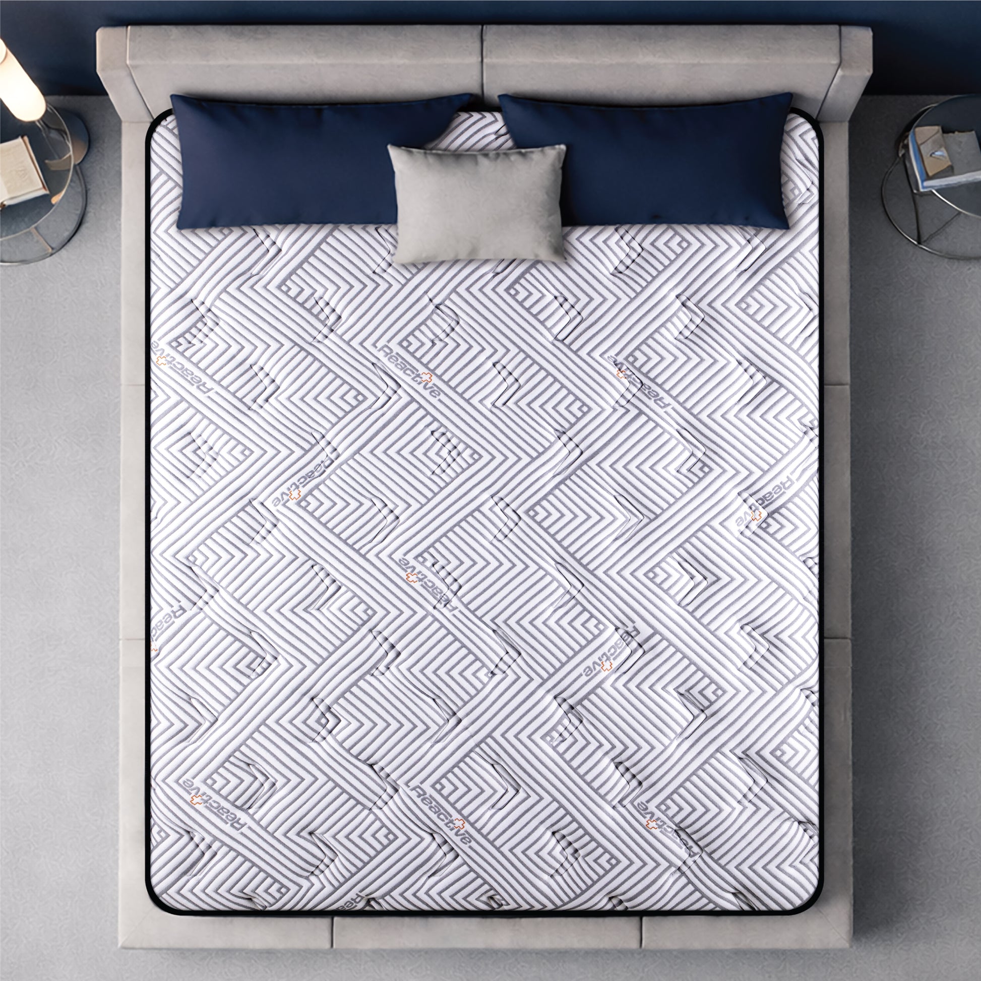 Springfit Reactive Gold mattress aerial top view showing white and grey geometric maze-pattern branded quilted fabric on beige platform bed with navy blue and grey pillows