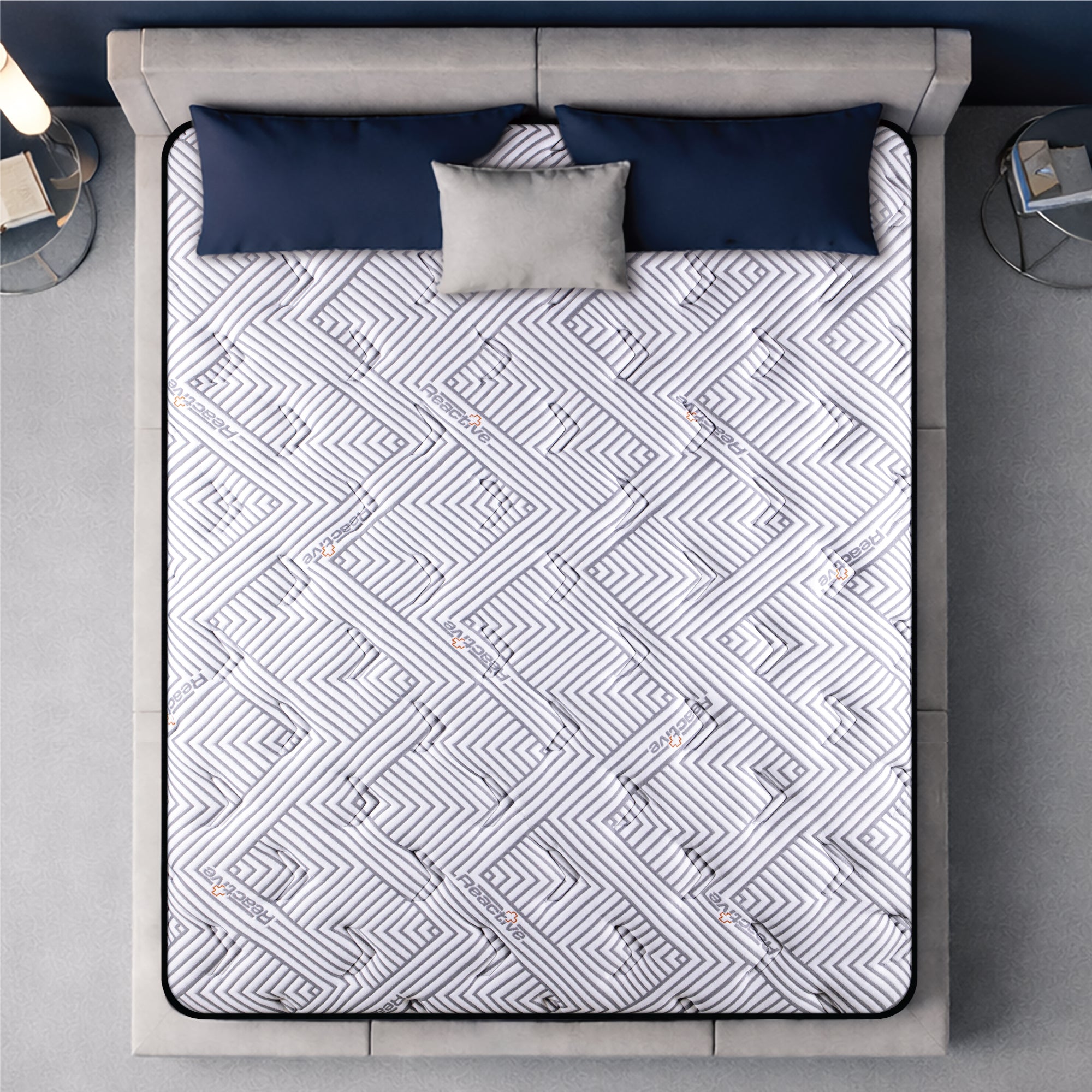 Springfit Reactive Gold mattress aerial top view showing white and grey geometric maze-pattern branded quilted fabric on beige platform bed with navy blue and grey pillows