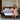 Springfit Reactive Ortho mattress lifestyle image with brand ambassador in pink floral dress seated on mattress edge on brown leather bed in warm neutral-toned luxury bedroom