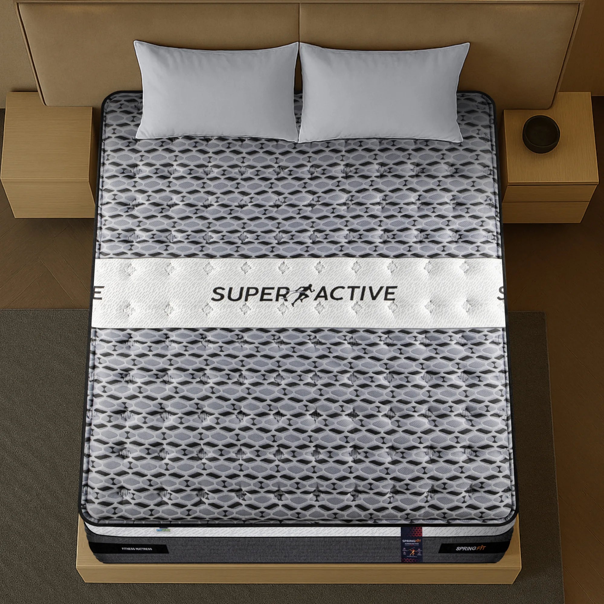 Top-down view of Springfit Super Active Hybrid fitness mattress showing hexagonal grey pattern fabric with prominent Super Active branding band and grey pillows