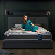Springfit Super Active Renew mattress with CertiPUR-US certification on a dark platform bed with brand ambassador seated in a modern dark-toned bedroom