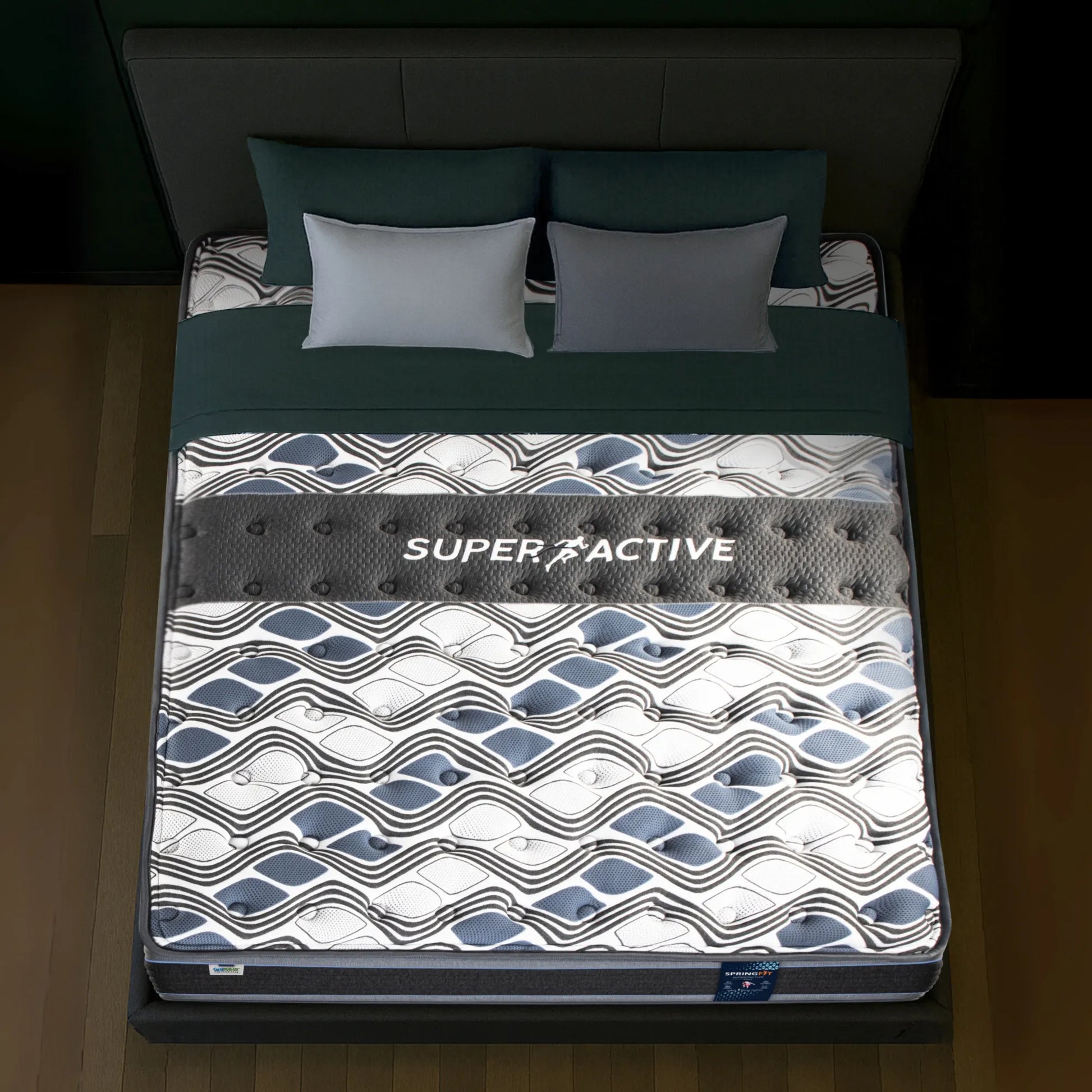 Top-down view of Springfit Super Active Renew mattress showing wave-patterned fabric with prominent Super Active branding band and grey pillows