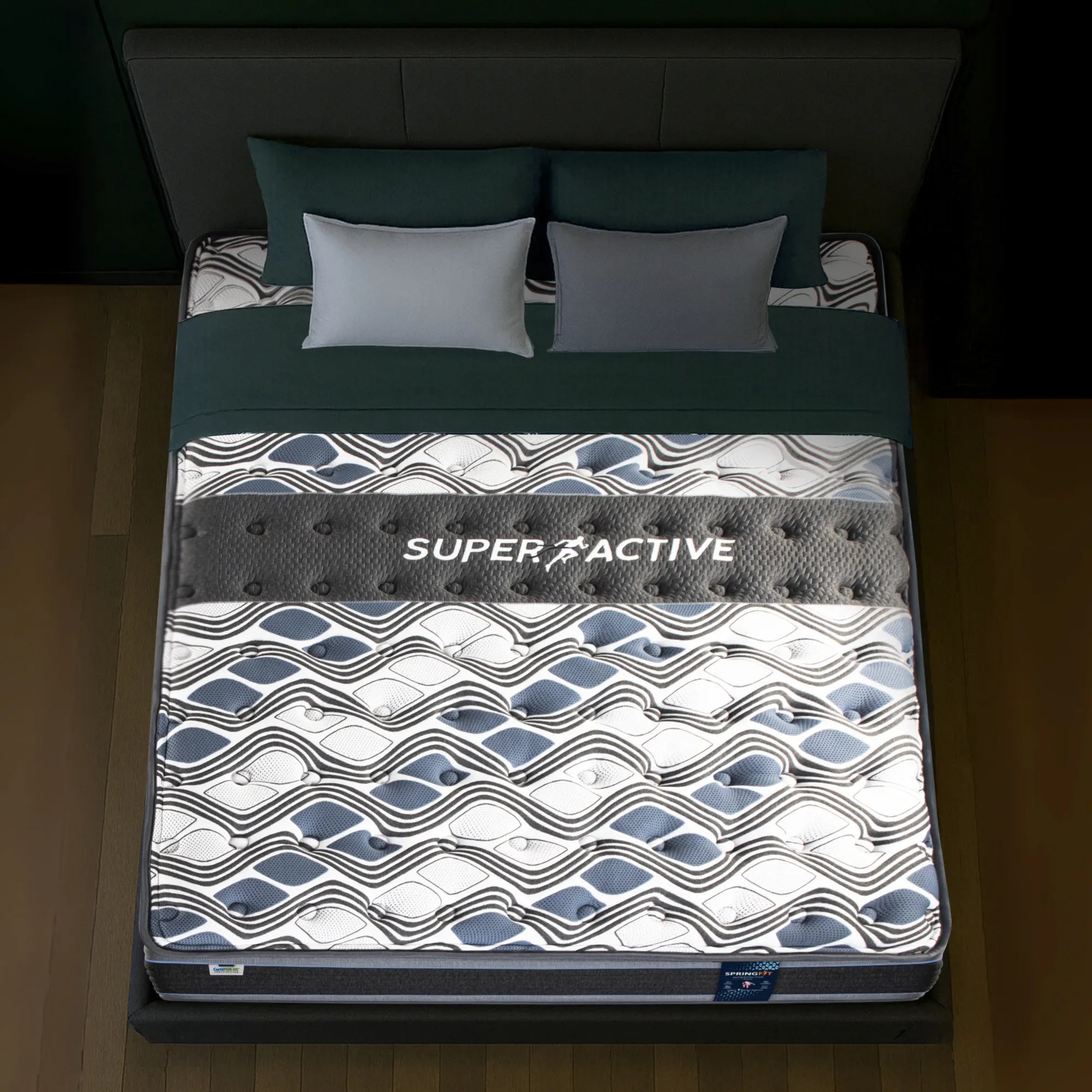 Top-down view of Springfit Super Active Renew mattress showing wave-patterned fabric with prominent Super Active branding band and grey pillows