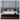 Springfit Wellness Orthopedic mattress placed on a dark wooden bed frame in a luxurious bedroom with a panoramic ocean view and warm floor lamps