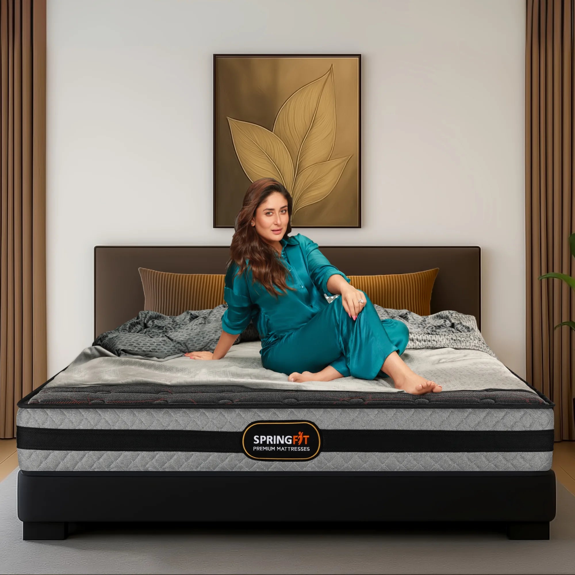 Springfit ZBox premium mattress on a black bed frame with brand ambassador seated on it in a warm bedroom setting