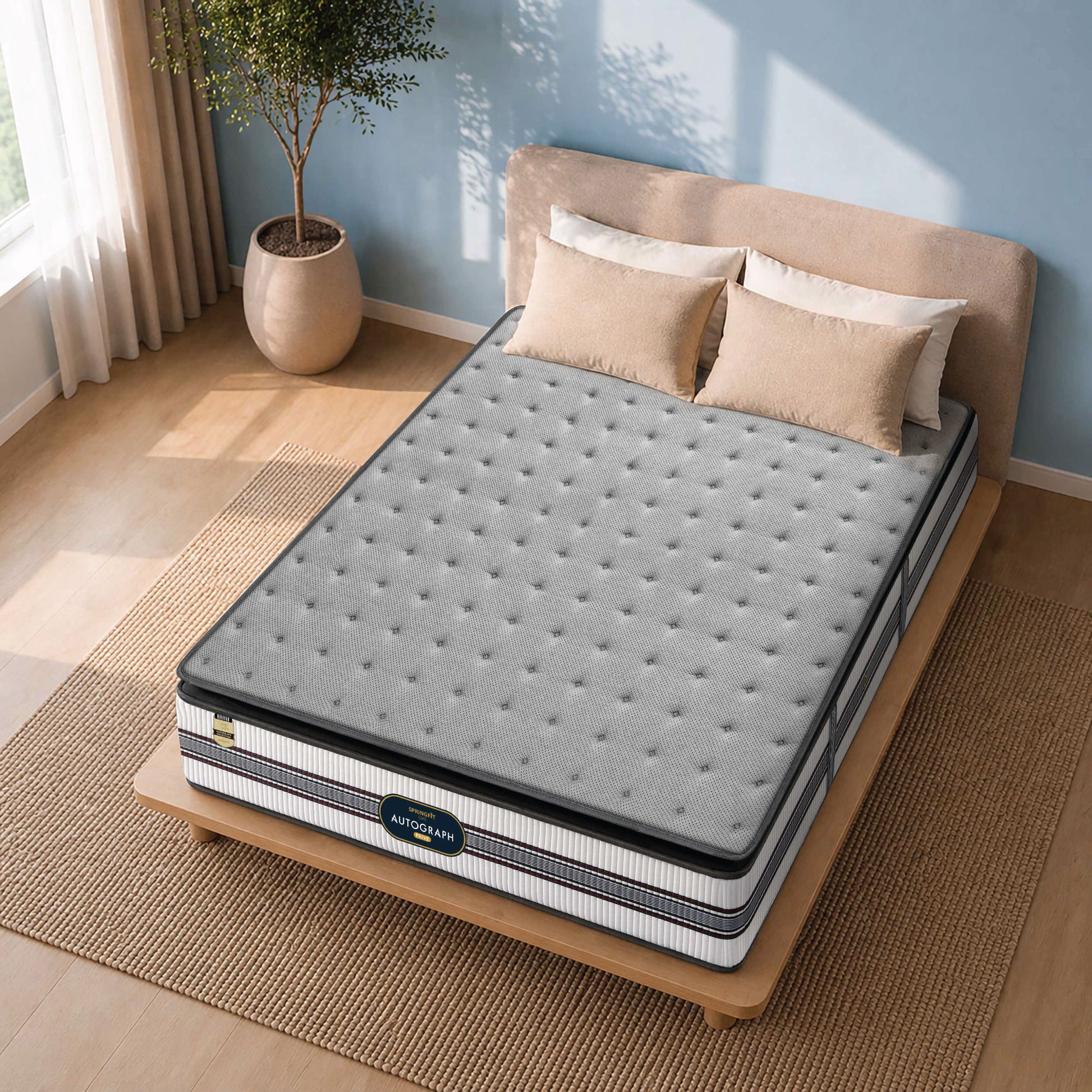 Gray mattress on a wooden bed frame with pillows in a bedroom setting.